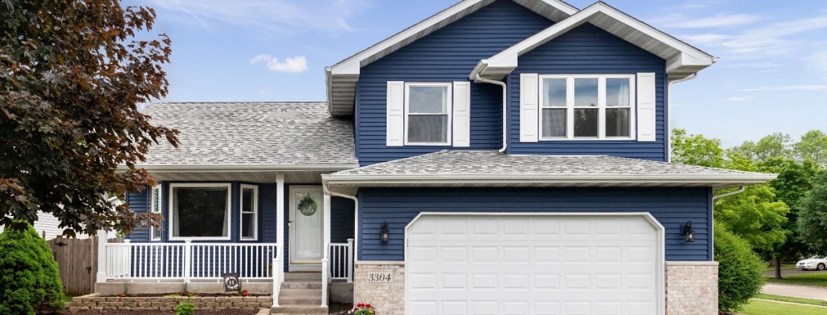 A two storey home with blue siding and white trimwork.